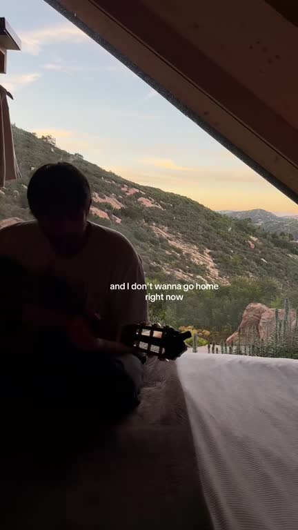 Daniel singing on a porch over the hills